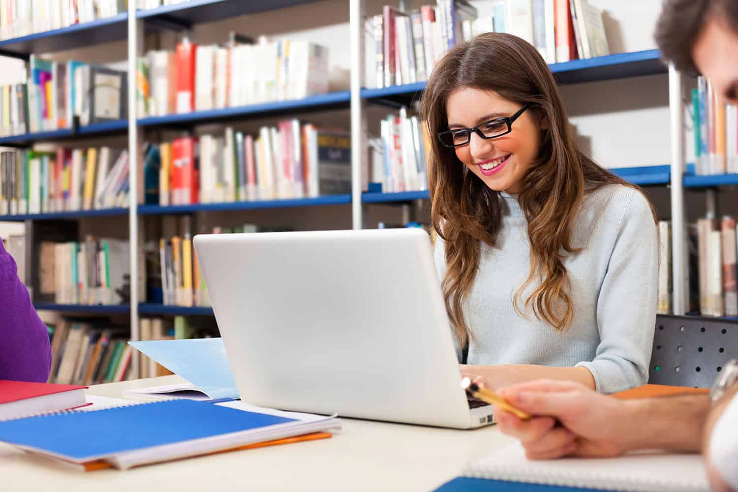 Young woman studying accounting at Pantelis Stylianides Institute of Accounting with laptop and books.